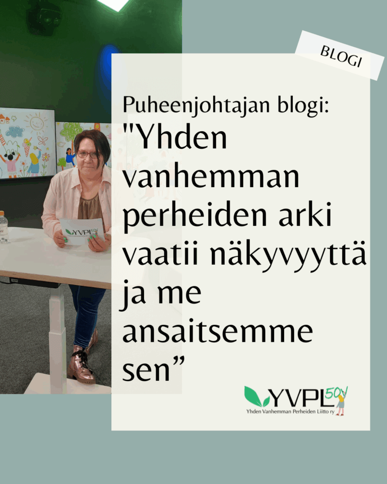Kuvassa on henkilö, joka seisoo pöydän edessä pidellen paperia. Taustalla on värikkäitä piirustuksia. Kuvassa on myös teksti: Puheenjohtajan blogi: 'Yhden vanhemman perheiden arki vaatii näkyvyyttä ja me ansaitsemme